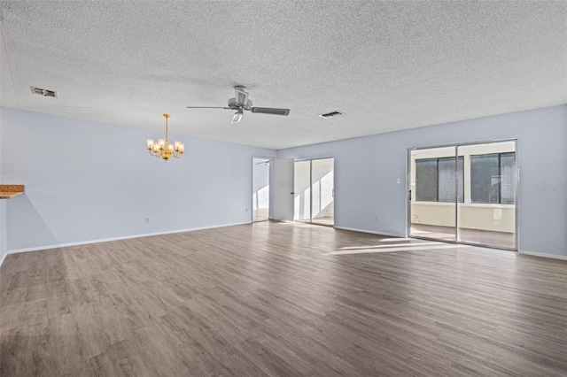 spare room with ceiling fan with notable chandelier, plenty of natural light, hardwood / wood-style floors, and a textured ceiling