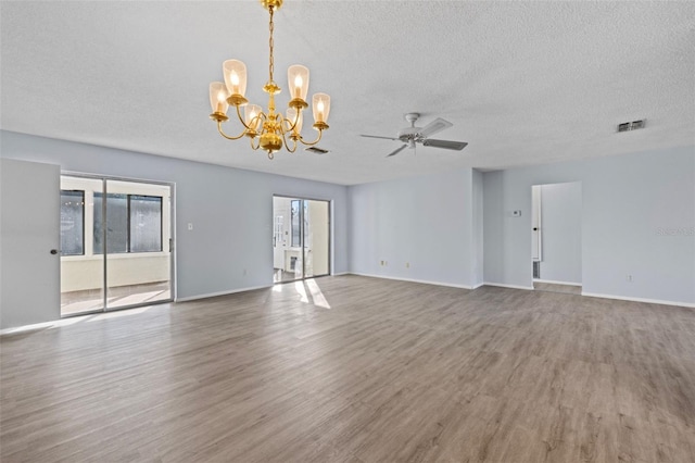 unfurnished room featuring ceiling fan with notable chandelier, wood-type flooring, and a textured ceiling