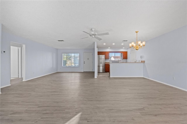 unfurnished living room featuring plenty of natural light, a textured ceiling, and light hardwood / wood-style floors