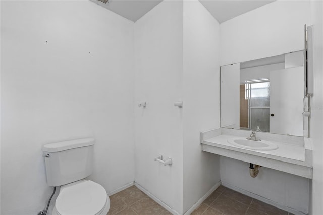 bathroom featuring toilet, tile patterned flooring, and sink