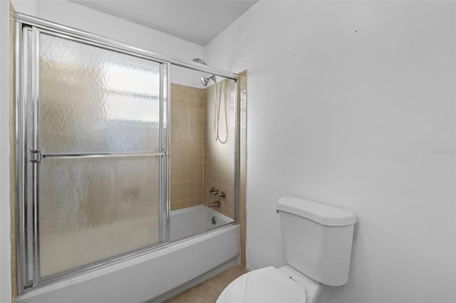 bathroom featuring shower / bath combination with glass door and toilet