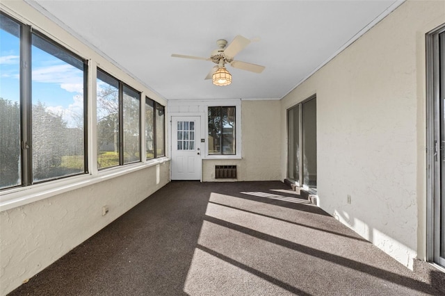 unfurnished sunroom featuring ceiling fan