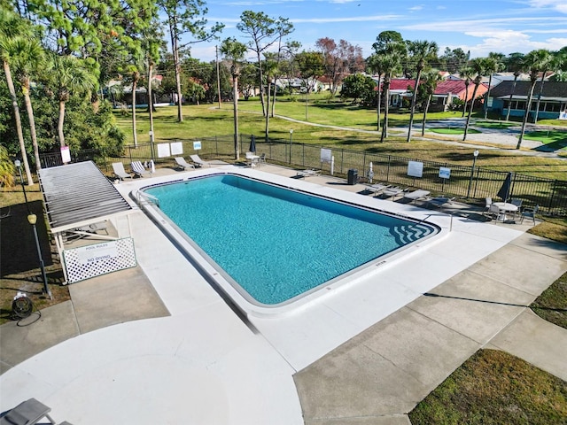 view of pool with a patio area and a lawn