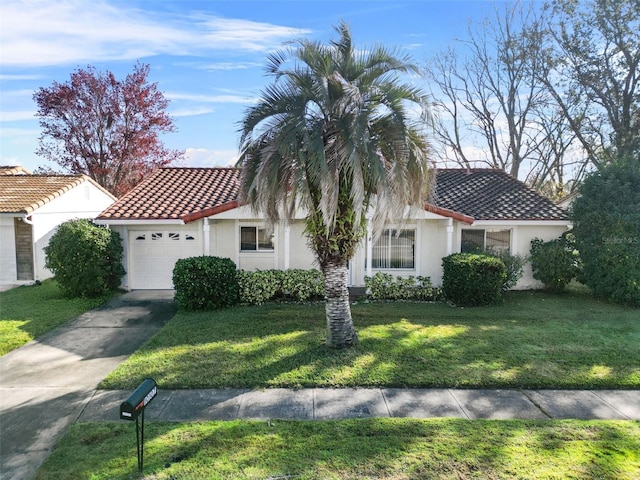 mediterranean / spanish home with a garage and a front lawn