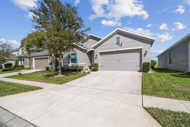 view of front of home with stucco siding, driveway, an attached garage, and a front lawn