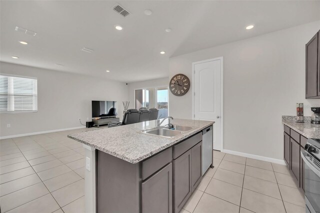 283 Archer Way, Haines City, FL 33844 - kitchen featuring dishwasher, an island with sink, sink, stove, and light tile patterned floors