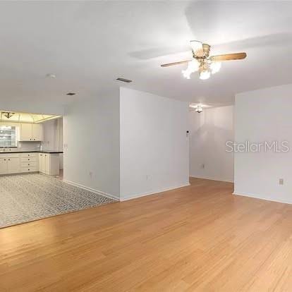 empty room with light hardwood / wood-style flooring and ceiling fan