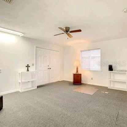 carpeted spare room featuring ceiling fan