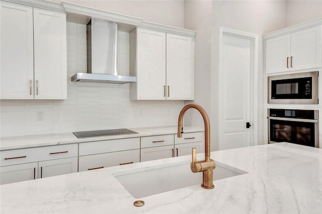 kitchen featuring black appliances, white cabinetry, sink, and wall chimney exhaust hood