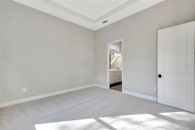 unfurnished bedroom featuring connected bathroom and carpet