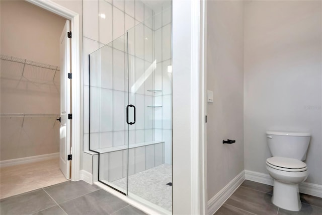 bathroom with toilet, an enclosed shower, and tile patterned flooring