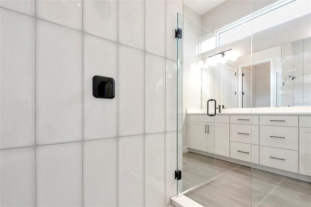 bathroom featuring tile patterned flooring, vanity, tile walls, and a shower with shower door