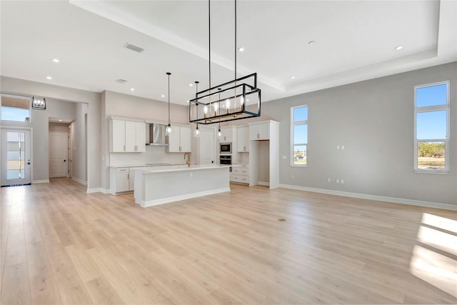 unfurnished living room with sink and light hardwood / wood-style flooring