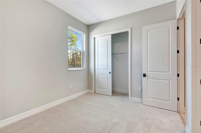 unfurnished bedroom featuring light colored carpet and a closet