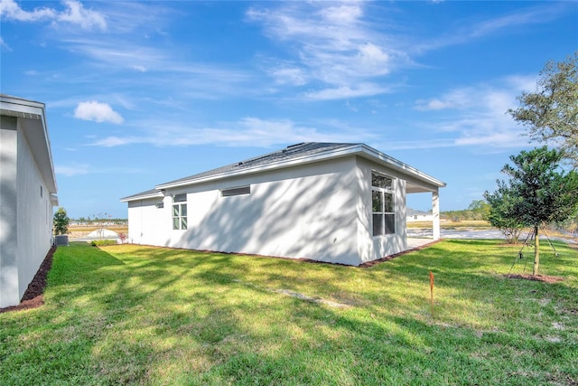 view of side of home with a yard