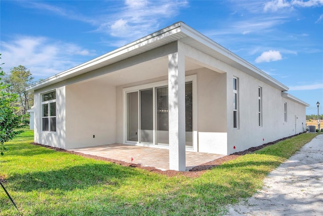 back of property featuring central AC, a yard, and a patio