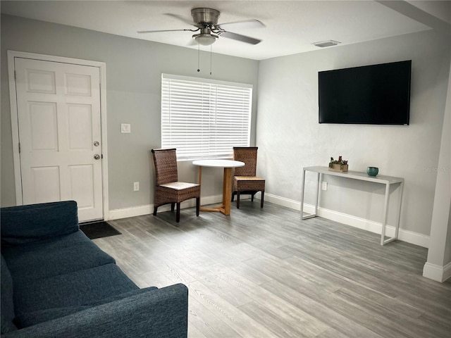 living room featuring hardwood / wood-style floors and ceiling fan