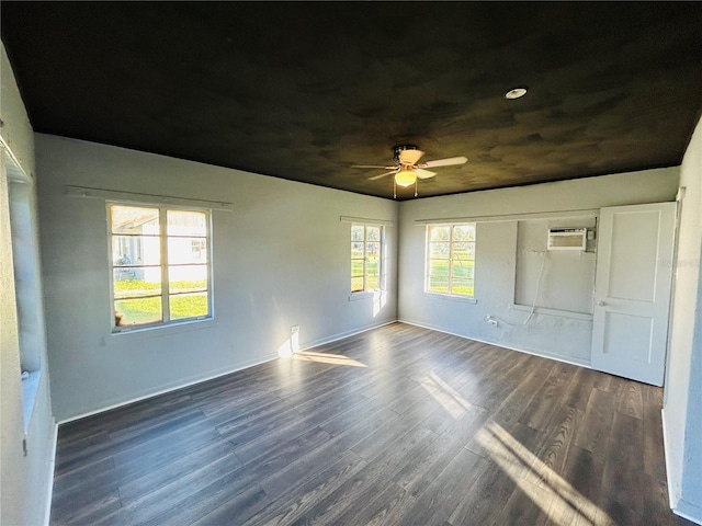 unfurnished bedroom with ceiling fan, dark hardwood / wood-style floors, and a wall mounted AC