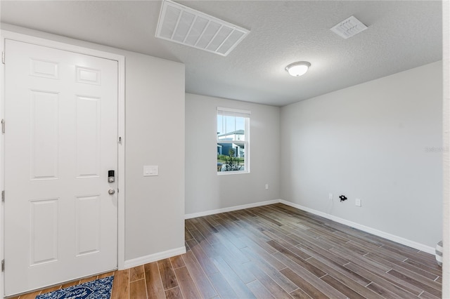 entrance foyer with dark hardwood / wood-style flooring and a textured ceiling