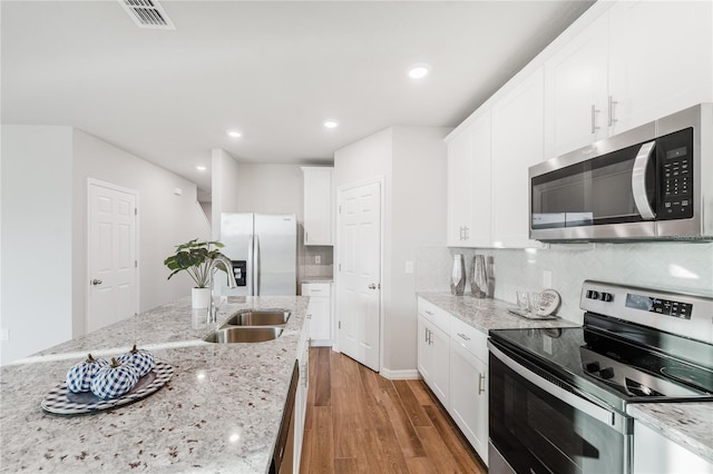 kitchen featuring appliances with stainless steel finishes, sink, white cabinets, and light stone counters