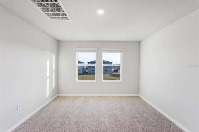 carpeted empty room with a textured ceiling