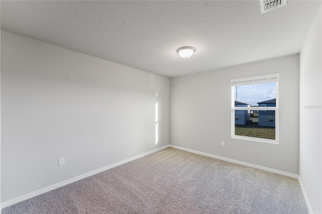 carpeted spare room featuring a textured ceiling