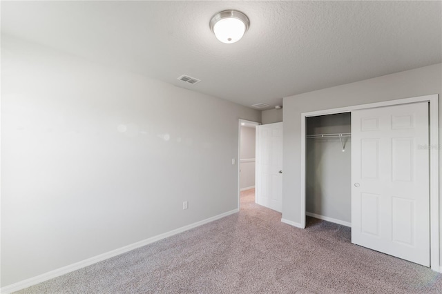 unfurnished bedroom featuring a closet, carpet flooring, and a textured ceiling