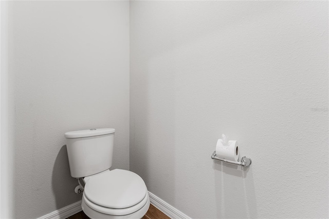 bathroom featuring hardwood / wood-style flooring and toilet