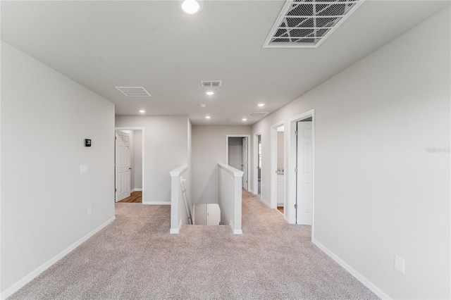 corridor featuring light colored carpet