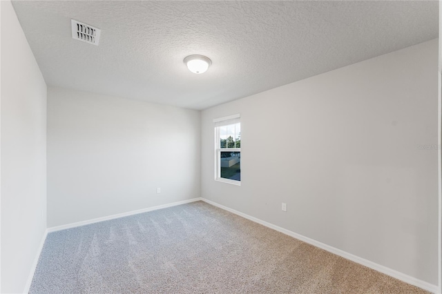 carpeted empty room featuring a textured ceiling