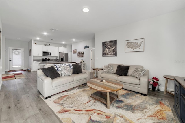 living room with sink and light wood-type flooring