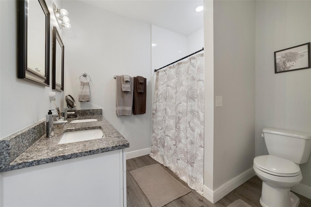 bathroom with wood-type flooring, toilet, curtained shower, and vanity