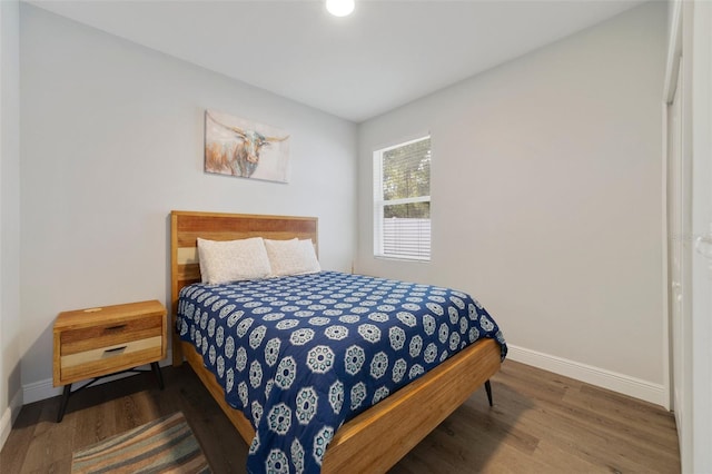 bedroom with dark wood-type flooring