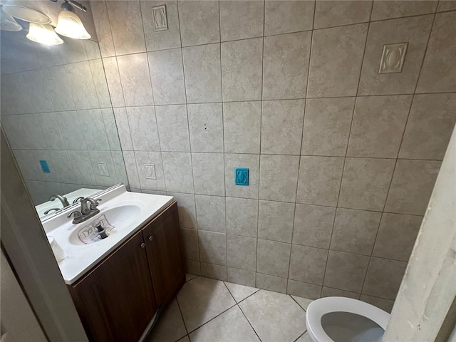 bathroom featuring tile patterned flooring, vanity, tile walls, and toilet