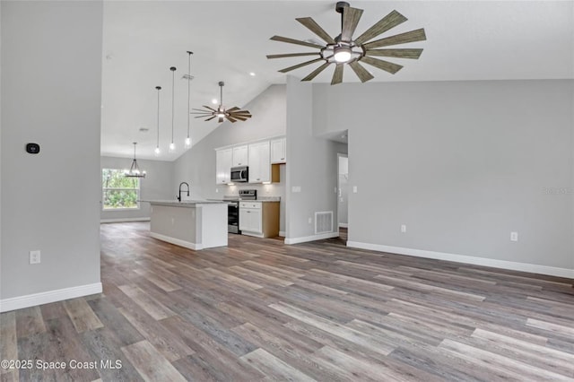 unfurnished living room featuring high vaulted ceiling, sink, ceiling fan with notable chandelier, and light hardwood / wood-style floors