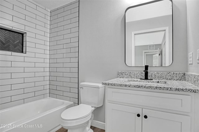 full bathroom featuring tiled shower / bath combo, vanity, and toilet