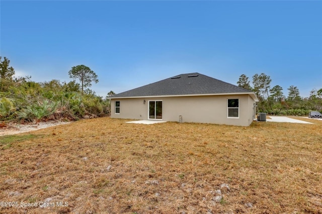 rear view of property with a patio, central AC unit, and a lawn