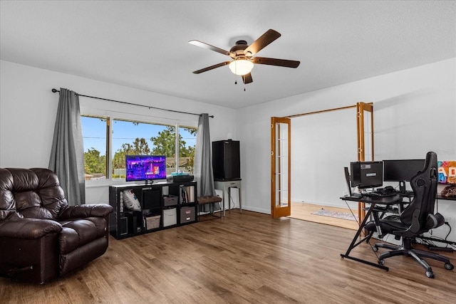 home office with hardwood / wood-style flooring and ceiling fan