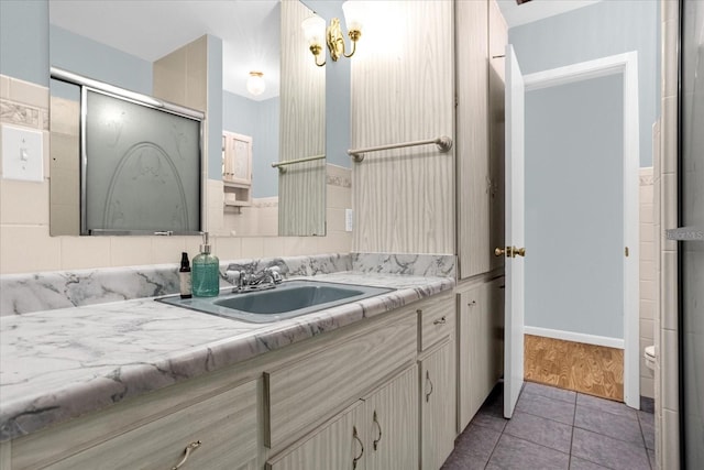 bathroom with an enclosed shower, vanity, and tile patterned flooring