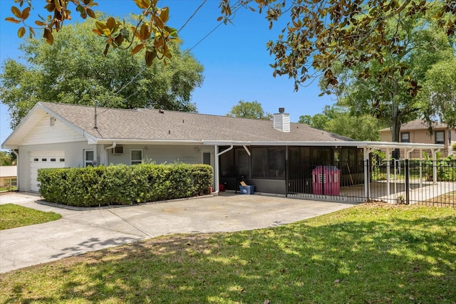 view of front of home featuring a garage, a front yard, and a sunroom