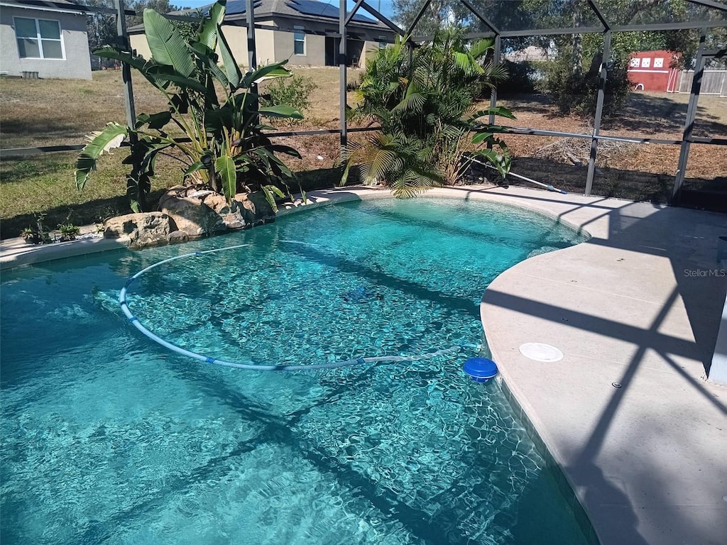 view of pool featuring glass enclosure