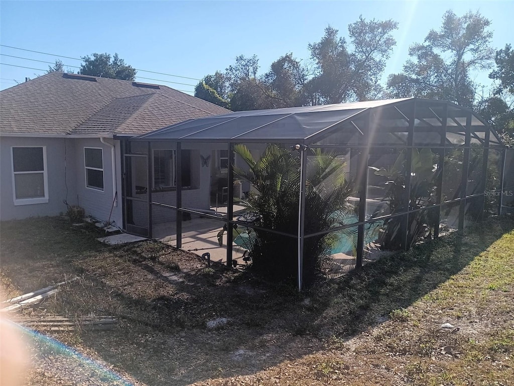 rear view of house featuring a lanai and a patio area