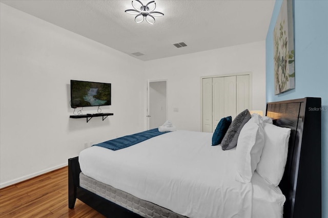 bedroom with hardwood / wood-style flooring, a closet, and a textured ceiling