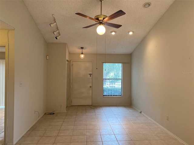 unfurnished room with a textured ceiling, a ceiling fan, baseboards, and light tile patterned flooring