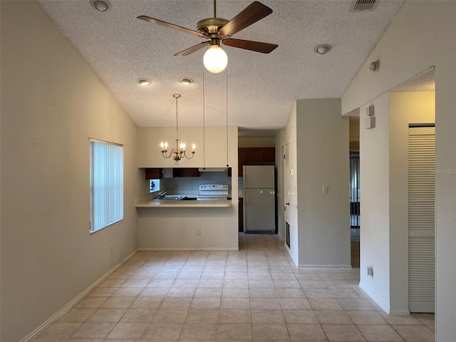 kitchen with freestanding refrigerator, electric range, light countertops, ceiling fan with notable chandelier, and a textured ceiling