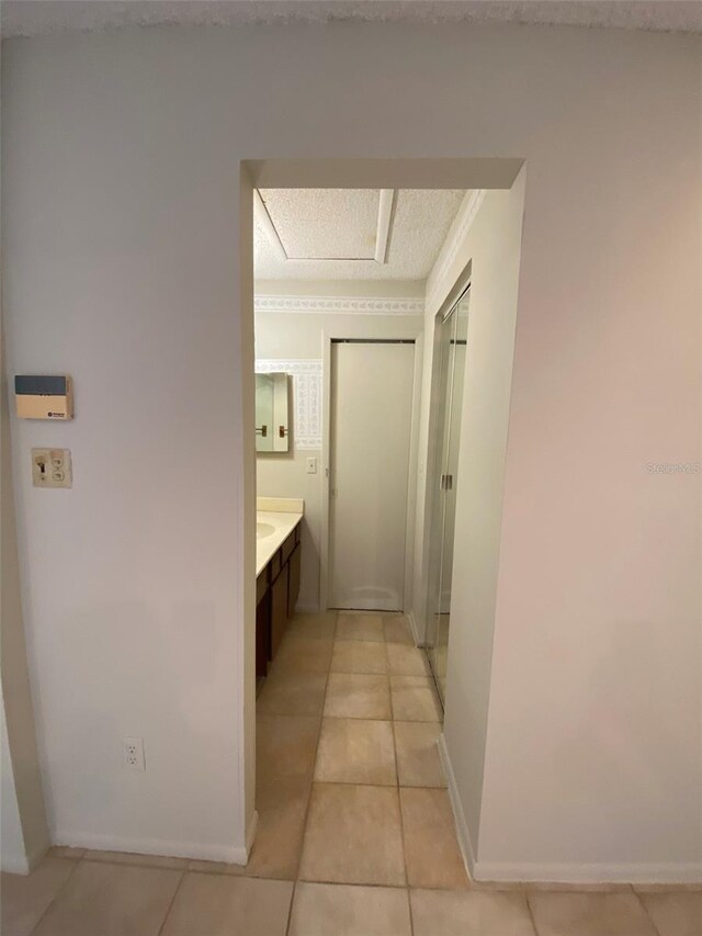 hall with light tile patterned flooring and baseboards