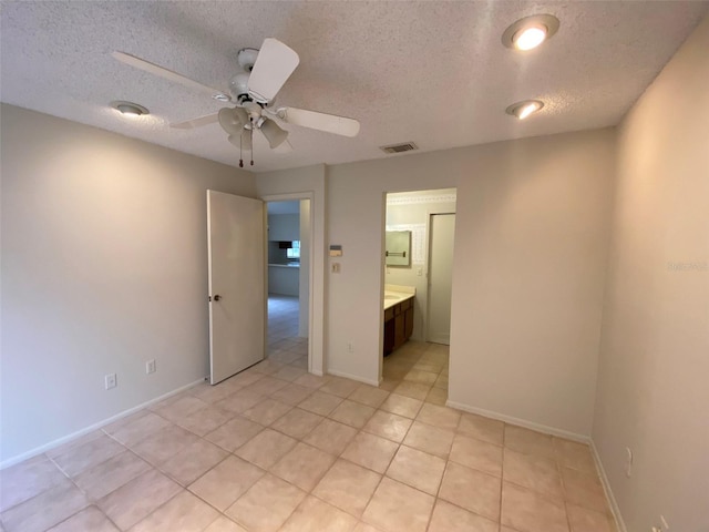 unfurnished bedroom with light tile patterned floors, baseboards, visible vents, a ceiling fan, and a textured ceiling