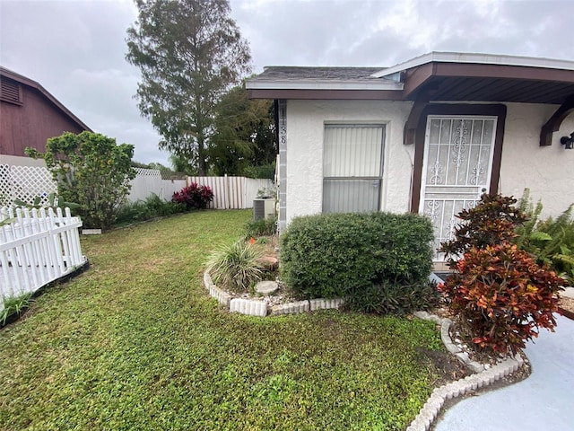 view of yard with fence and central AC