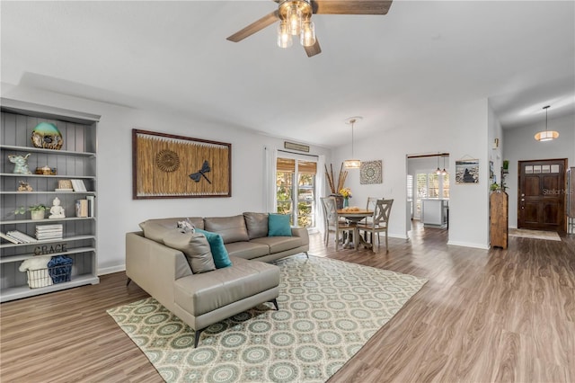 living room featuring lofted ceiling, hardwood / wood-style flooring, and ceiling fan