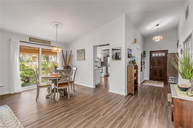 dining room featuring dark wood-type flooring and high vaulted ceiling